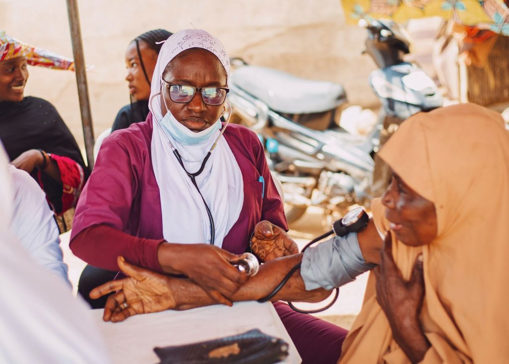 Healthcare worker checking a community member’s blood pressure